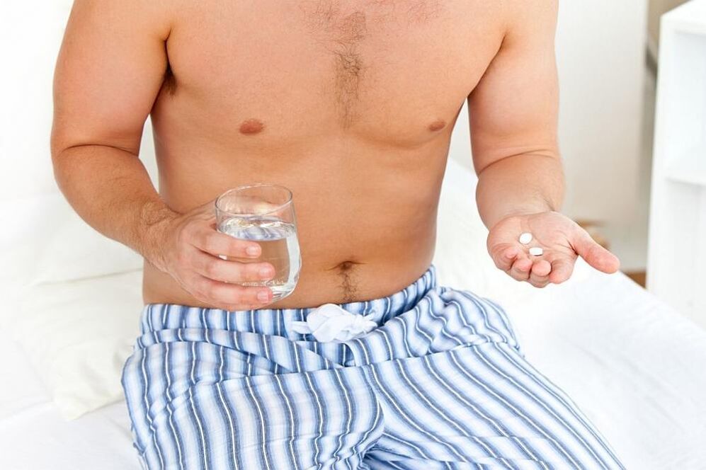 Mann hëlt Pillen fir Prostatitis