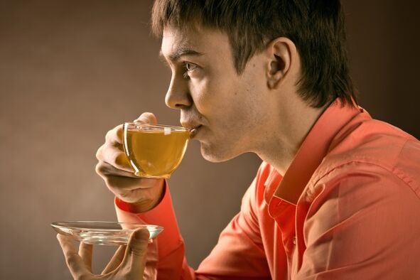 e Mann drénkt Kräutertee fir Prostatitis ze behandelen